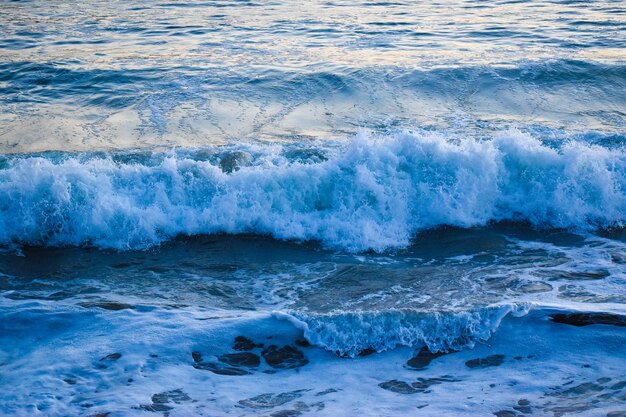 Photo les vagues qui éclaboussent sur le rivage