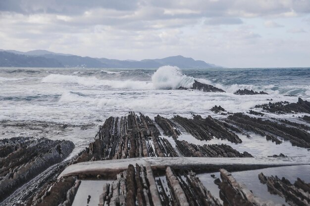 Photo les vagues s'écrasent sur les rochers.