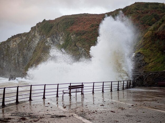 Vagues se brisant contre le jour orageux du point de vue touristique