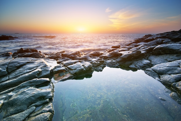 Vagues se brisant sur le rivage au coucher du soleil