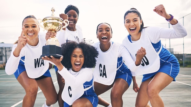 Vainqueur du netball et portrait de femmes avec trophée pour avoir remporté des jeux de compétition et un match sportif Succès du travail d'équipe et des athlètes féminines excitées avec un prix pour les objectifs de victoire et la réussite sur le terrain