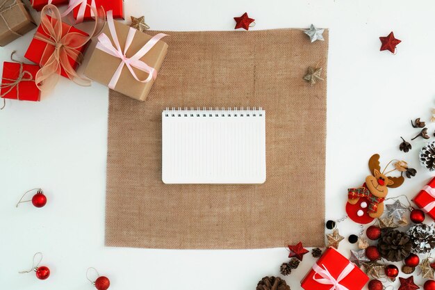 Vaisselle blanche et carnet de notes au-dessus du fond de Noël concept de conception de décoration de vacances composition d'ornement avec boîte à cadeaux de Noël étoile renne