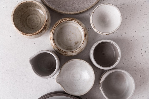 Vaisselle en céramique faite à la main, céramique artisanale vide sur fond clair. Assiettes et tasses en terre cuite