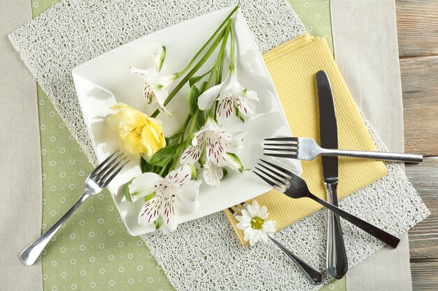 Vaisselle avec des fleurs sur la table se bouchent