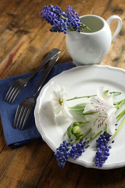 Vaisselle avec des fleurs sur la table se bouchent