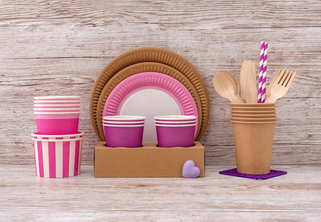 Vaisselle en papier artisanal écologique Assiette en papier rose tasse paille et couverts Fond en bois beige