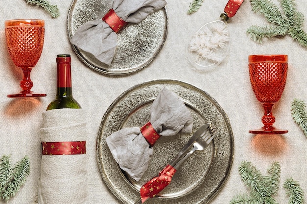 Vaisselle pour Noël ou dîner de fête de Noël serviette en lin sur assiette bouteille de vin en verre de vin rouge