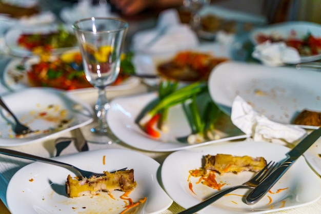 La vaisselle et les verres sont sales sur la table après avoir mangé Des assiettes vides avec des restes de nourriture après le dîner