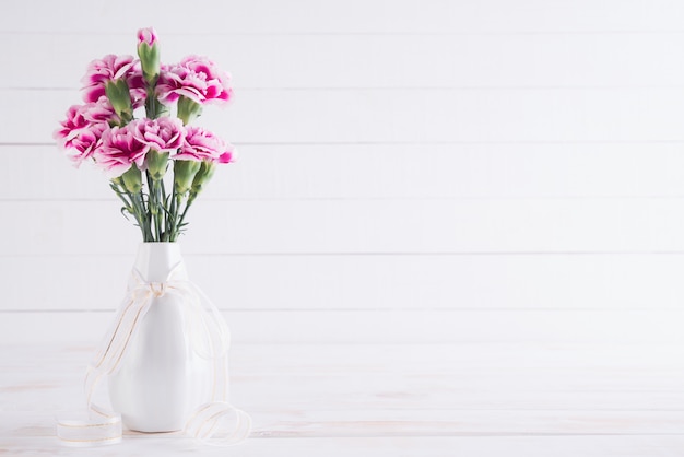 Photo valentin et concept de l'amour. fleur d'oeillet rose dans un vase