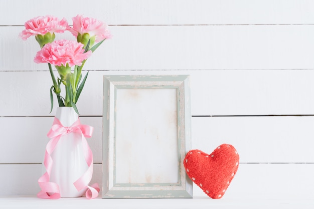 Valentin et concept de l&#39;amour. Oeillet rose dans un vase sur fond en bois.