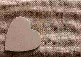 Photo valentine - symbole du coeur découpé dans du carton d'emballage sur du chanvre. espace de copie.