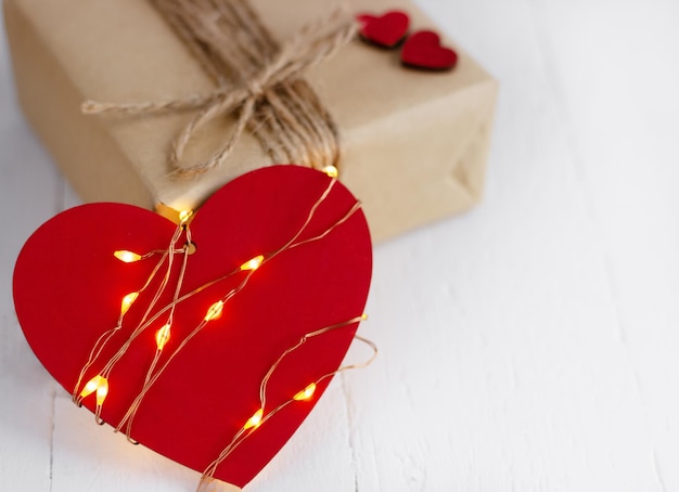 Valentine39s Day concept Coeur rouge avec la guirlande lumineuse et coffret cadeau sur le fond en bois blanc