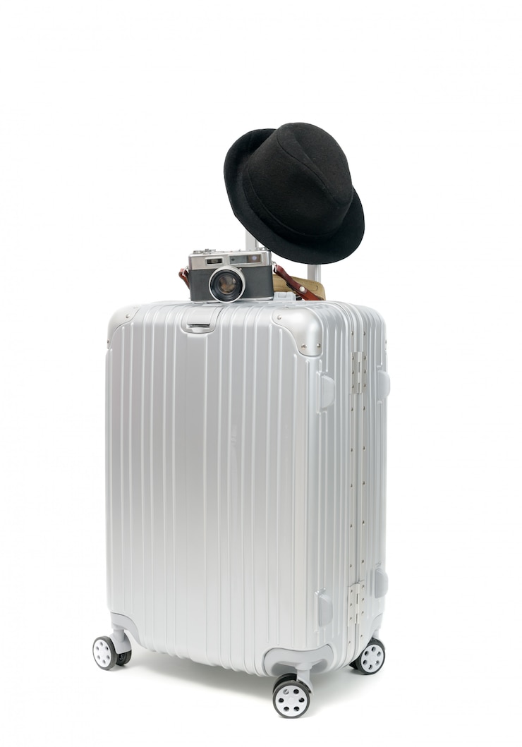Photo valise avec appareil photo vintage et chapeau noir isolé