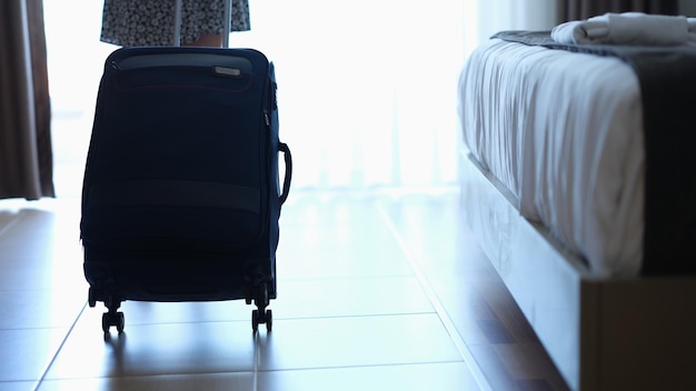 Valise bleue dans une chambre d'hôtel sombre