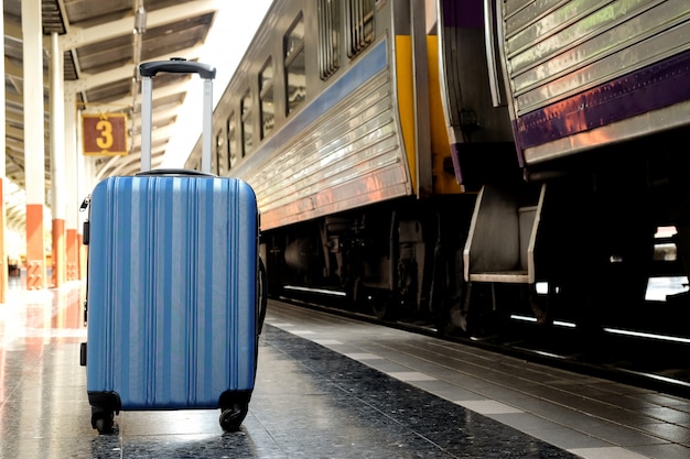 Valise bleue sur le quai du train.