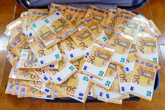 Valise bleue totalement pleine de billets de cinquante euros à l'intérieur