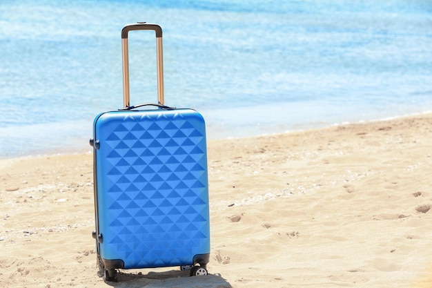 Valise emballée au bord de la mer Concept de vacances