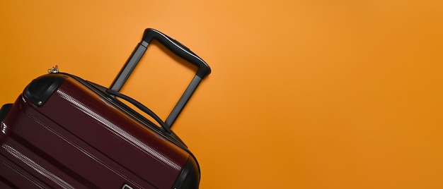 Une valise sur fond orange avec espace cop Préparation pour les vacances d'été