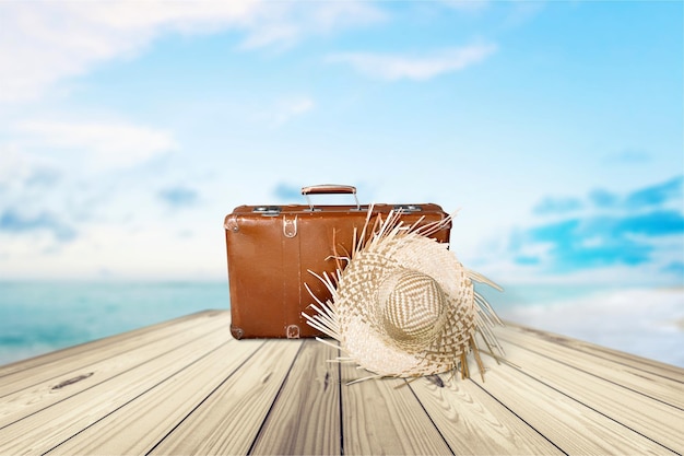 Valise rétro avec chapeau de voyage sur fond tropical