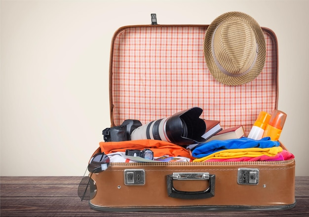 Valise rétro avec des objets de voyage sur fond