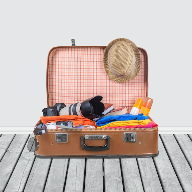 Valise rétro avec des objets de voyage sur fond