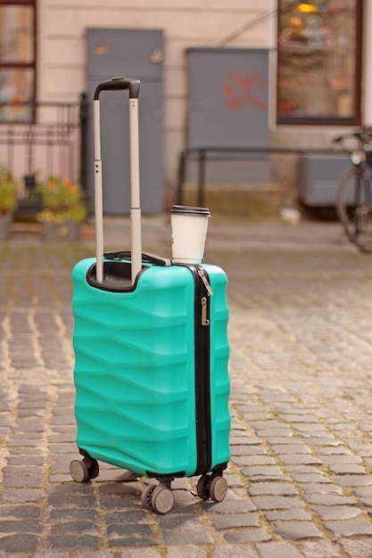une valise et une tasse de café sur le concept de voyage carré