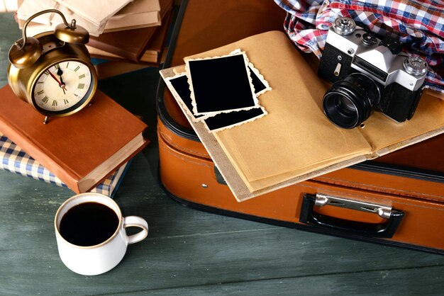 Photo valise vintage avec livres et appareil photo sur fond de bois