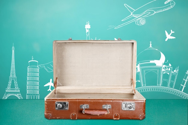 Une valise vintage vide ouverte sur le vert