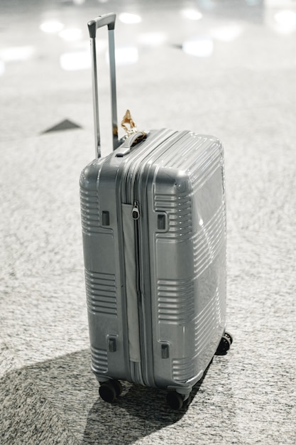 Valise de voyage grise dans le hall de l'aéroport vide