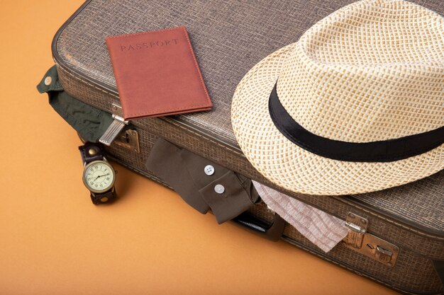 Photo valise de voyage remplie de vêtements et chapeau de paille