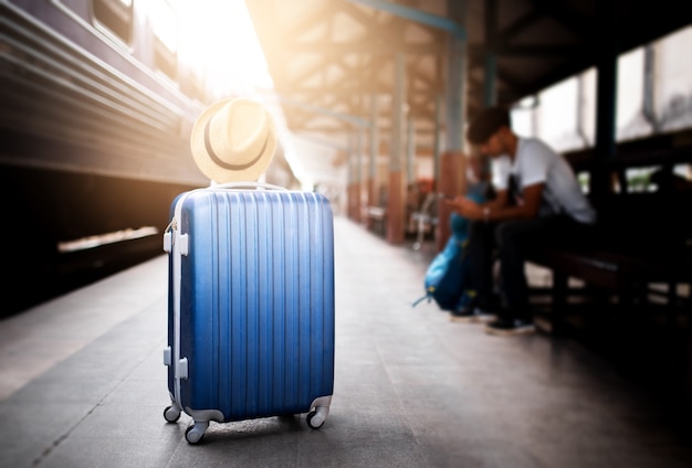 Valises avec voyageur assis dans la gare.