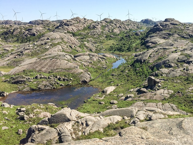 Vallée rocheuse pittoresque avec les contours de l'éolienne à l'horizon