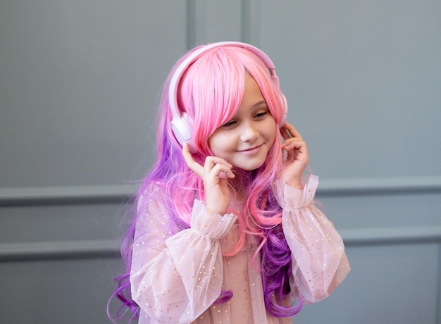 Vanilla Girl Kawaii vibes Petite fille aux cheveux roses fait une fête en style barbie Écoute de la musique avec des écouteurs téléphone portable