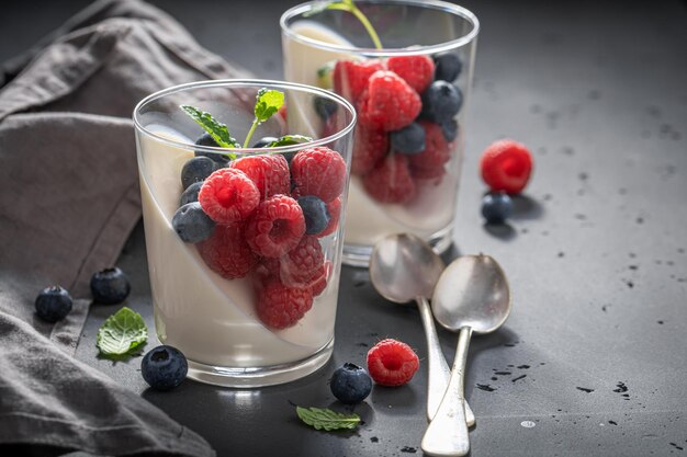 Vanille et Panna Cotta sucrée servie avec des baies en verre