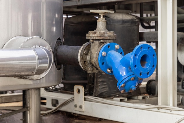 Vanne en métal bleu de type volant et tuyaux équipements industriels à l'usine de vin en gros plan