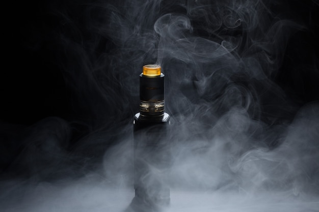 Vape close-up dans une fumée sur fond noir