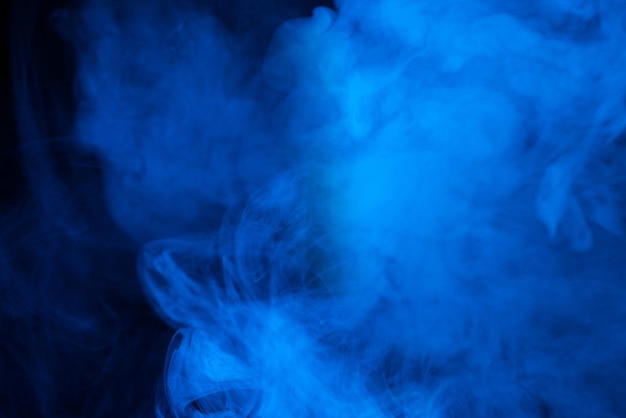 Vapeur bleue sur fond noir Copiez l'espace