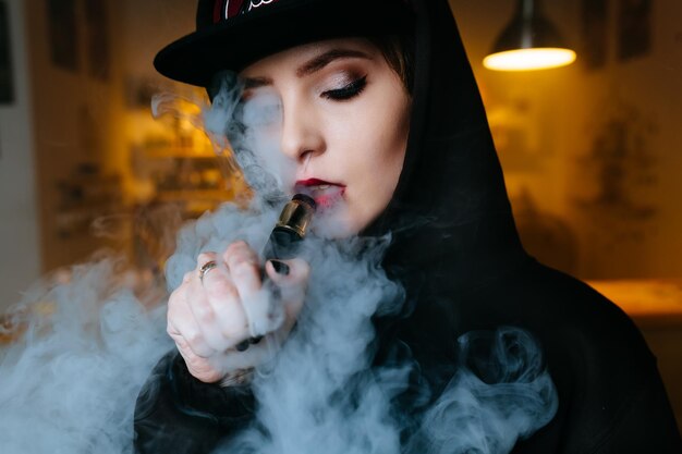 Vaping fille jeune hipster femme vape ecig au gros plan de style vapeshop hiphop