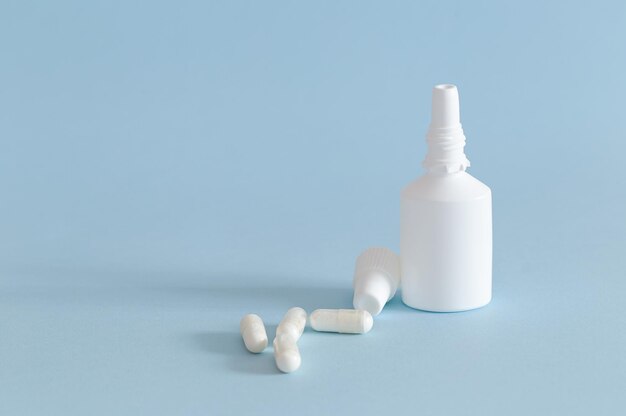 Photo un vaporisateur nasal avec quelques capsules de médicaments à côté de l'horizontale