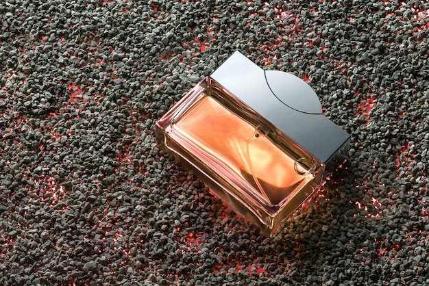Photo vaporisateur de parfum sur le fond de sable. image du modèle publicitaire.