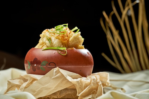 Varenyky avec pommes de terre oignons frits et saindoux dans une assiette sur une nappe blanche Cuisine ukrainienne