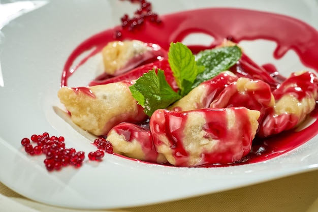 Varenyky ukrainien avec des cerises dans une assiette blanche de nappe blanche Lumière dure Mise au point sélective