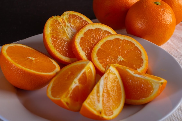 Varias naranjas cortadas en un plato blanco, vista cerrada, vista cercana de fruta fresca