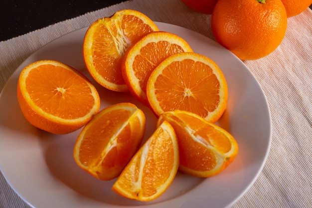 Varias naranjas cortadas en un plato blanco, vista cerrada, vista cercana de fruta fresca