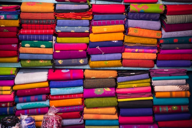 Variété artistique de couleurs de ton d'ombre Saree's empilés sur l'étagère de la boutique de vente au détail à vendre