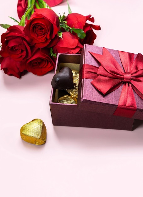 Variété de cadeaux et de chocolats en forme de coeur doré fond rose isolé concept Valentine39s