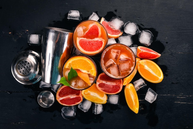 Une variété de cocktails de jus d'orange et de pamplemousse de whisky Negroni Sur un fond noir en bois Vue de dessus Espace de copie