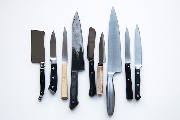 Une variété de couteaux sur un fond uni Concept de crime de couteau