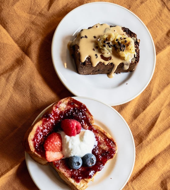 Photo variété de deux desserts un pain à la banane et un toast à la brioche avec des baies et des bleuets