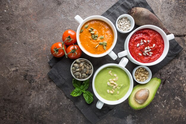 Variété de différentes soupes à la crème de légumes colorées dans des bols, vue de dessus. Concept d'alimentation saine ou de nourriture végétarienne.